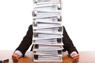 Person behind stack of binders